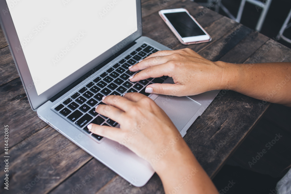 Crop faceless lady typing on keyboard of laptop while working at table Crop faceless lady typing on keyboard of laptop while working at table