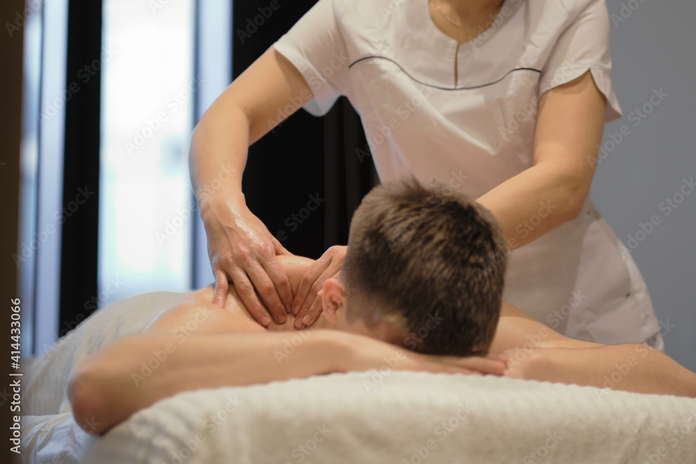 Close-up of man enjoying in relaxing shoulders massage . Man relaxing on massage table receiving massage Close-up of man enjoying in relaxing shoulders massage . Man relaxing on massage table receiving massage