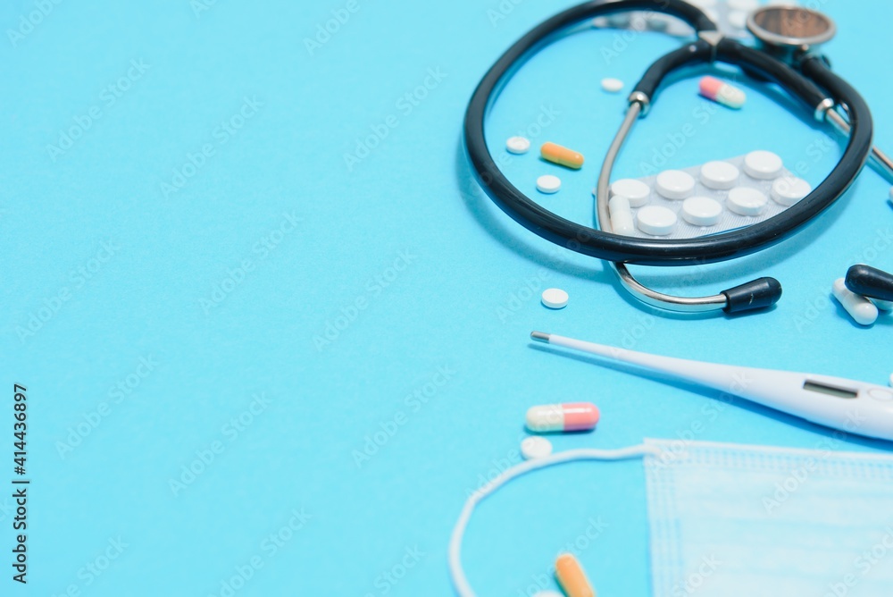 Top view of medicines, work tools and accessories doctor, nurse. Medical set - Tablets, thermometer, syringe, ampoules, adhesive plaster and statoscope on a blue background. Flat lay Top view of medicines, work tools and accessories doctor, nurse. Medical set - Tablets, thermometer, syringe, ampoules, adhesive plaster and statoscope on a blue background. Flat lay