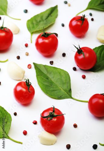 Tomato, basil, spices, pepper, garlic. Vegan diet food, creative cherry tomato composition isolated on white.
