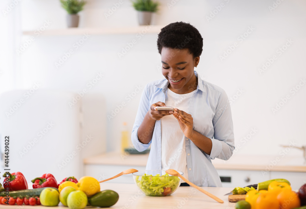 Female Blogger Taking Photo Of Healthy Dinner Cooking In Kitchen