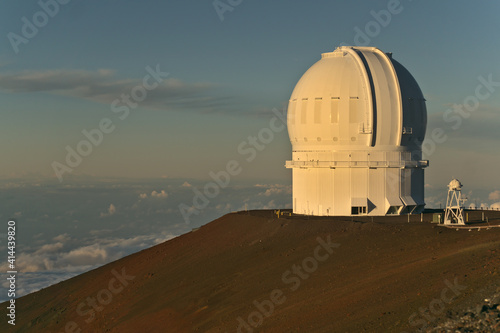 Closeup of the Canada - France - Hawaiʻi Telescope at Mauna Kea, Big Island, Hawai'i, during sunset against a gray blue sky