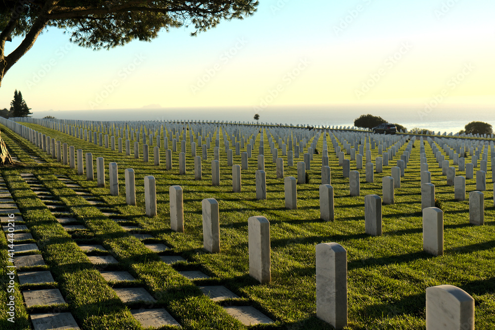 Sunset view of Fort Rosecrans National Cemetery overlooking the Pacific Ocean; back facing tombstones; Point Loma, San Diego, California