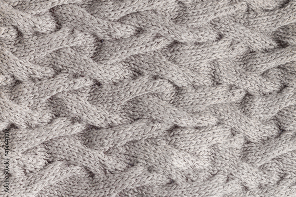 Knitted fabric, gray scarf with a pattern of wool yarn Knitted fabric, gray scarf with a pattern of wool yarn