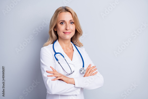 Foto Photo of sweet confident mature lady doctor wear white coat arms crossed empty s