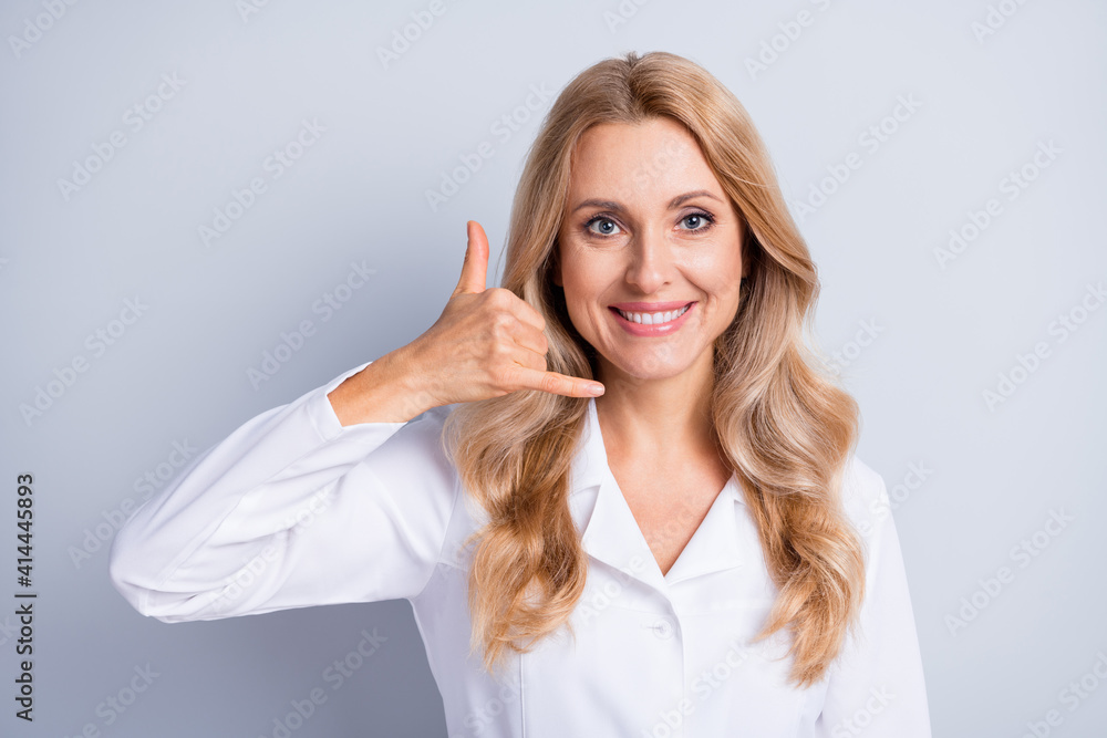 Portrait of beautiful lady fingers show phone symbol have good mood isolated on grey color background Portrait of beautiful lady fingers show phone symbol have good mood isolated on grey color background