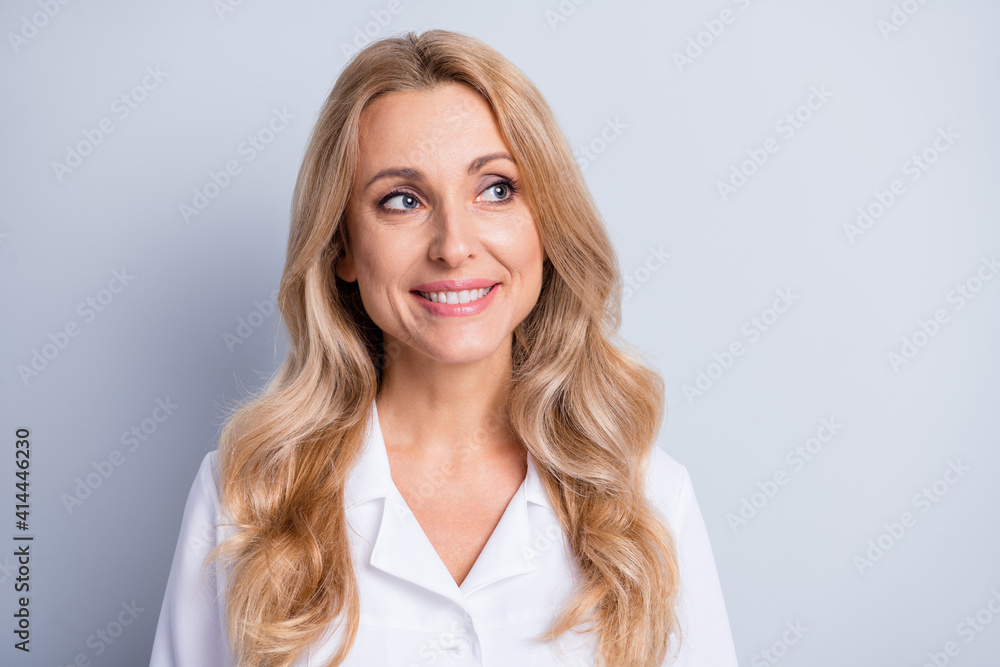 Photo of mature beautiful attractive happy smiling woman doctor look copyspace isolated on grey color background Photo of mature beautiful attractive happy smiling woman doctor look copyspace isolated on grey color background
