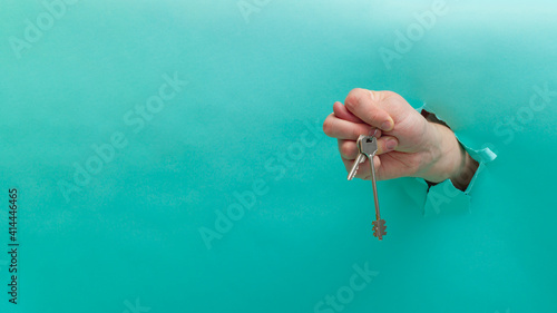 Bild auf Leinwand The man holds the keys to the apartment in his hand and shows the gesture of con