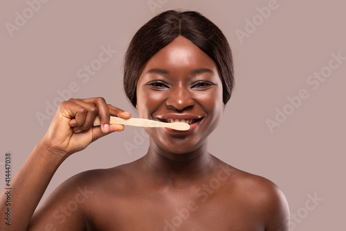 Happy African American Woman Brushing Her Teeth With Eco Bamboo Wooden Toothbrush