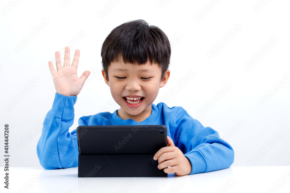 Happy little Asian boy is meeting and talking in video chat. Stay at home during the quarantine. Communication with relatives and friends online. Happy little Asian boy is meeting and talking in video chat. Stay at home during the quarantine. Communication with relatives and friends online.