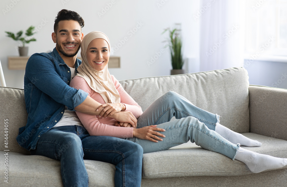 Handsome arab man embracing his pretty wife, spending weekend together