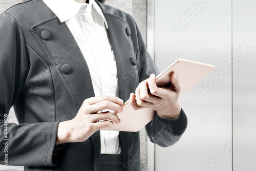 Businesswoman standing while using tablet
