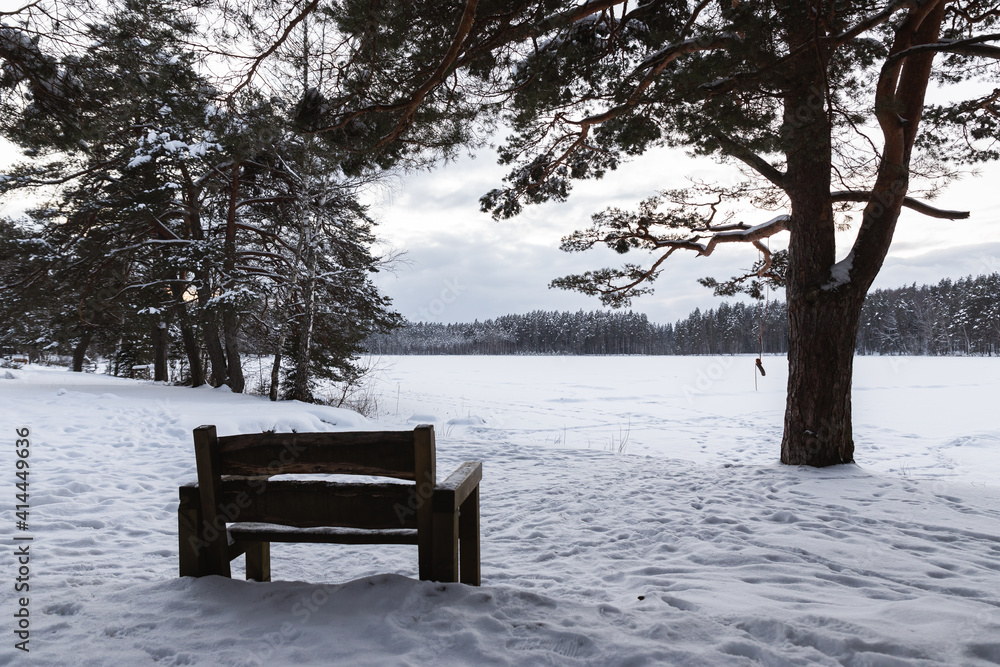 snow covered frozen lake in the winter Latvia Ninieris Cesis sunset landscape wooden bench 