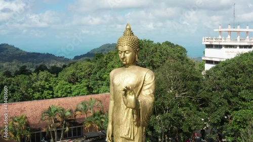 Flight over big golden buddha at Teepangkorn temple, Koh Samui photo