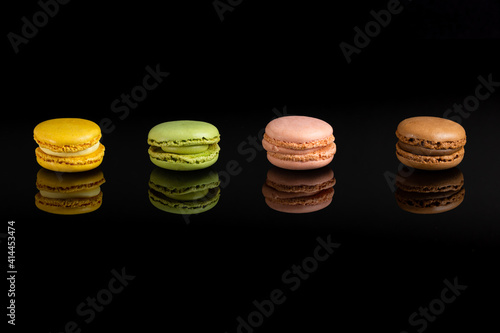 Multicolored macarons on a black background