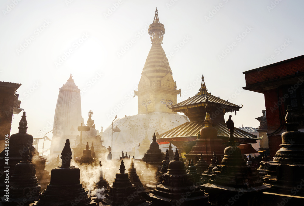 Fototapeta premium Swayambhunath stupa in Kathmandu, Nepal. Backlit smoke in the morning light.