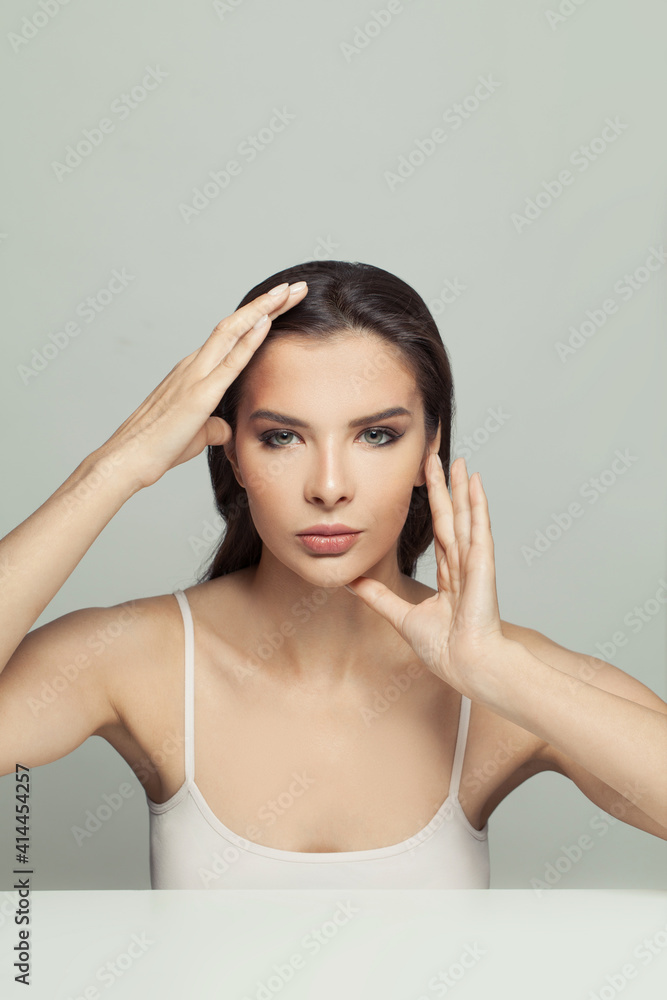 Face gymnastics concept. Beautiful woman holding her hands near her face. Massage, face gymnastics and cosmetology concept Face gymnastics concept. Beautiful woman holding her hands near her face. Massage, face gymnastics and cosmetology concept