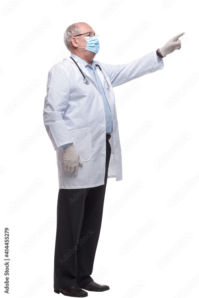 in full growth. a doctor in a protective mask pointing at you in full growth. a doctor in a protective mask pointing at you
