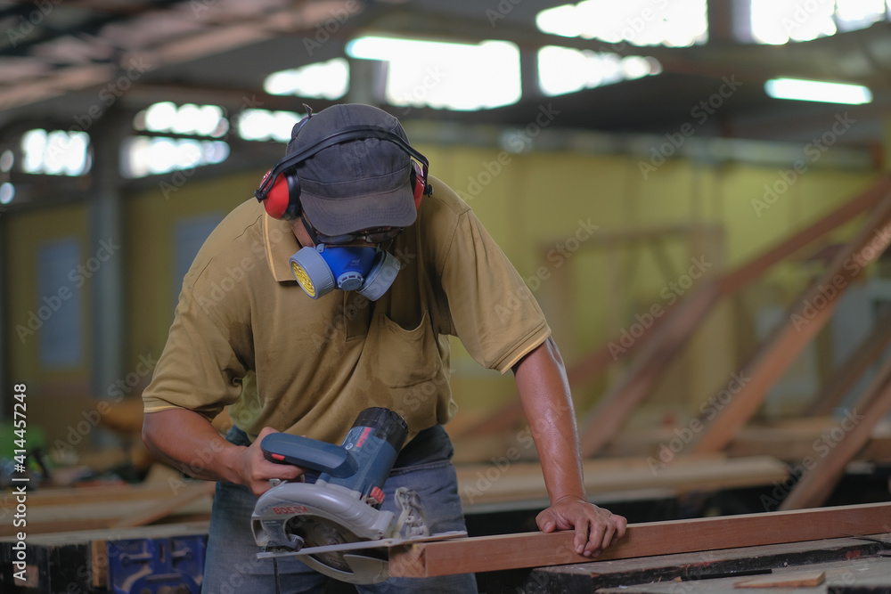 Carpenter using power circular saw in installation of roof rafters on a new gazebo construction project Carpenter using power circular saw in installation of roof rafters on a new gazebo construction project