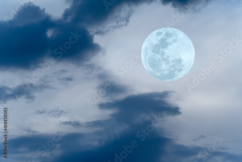 Full moon with blurred clouds on the sky.