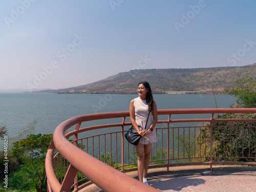 happy asian woman tourist relax at Lamtakong dam view point terrace, travel destination in Nakhon Ratchasima, Thailand