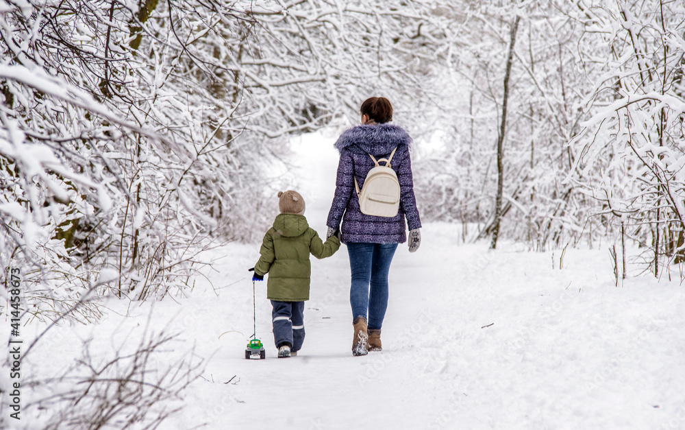 A woman with her son walking in a winter Park
A woman with her son walking in a winter Park