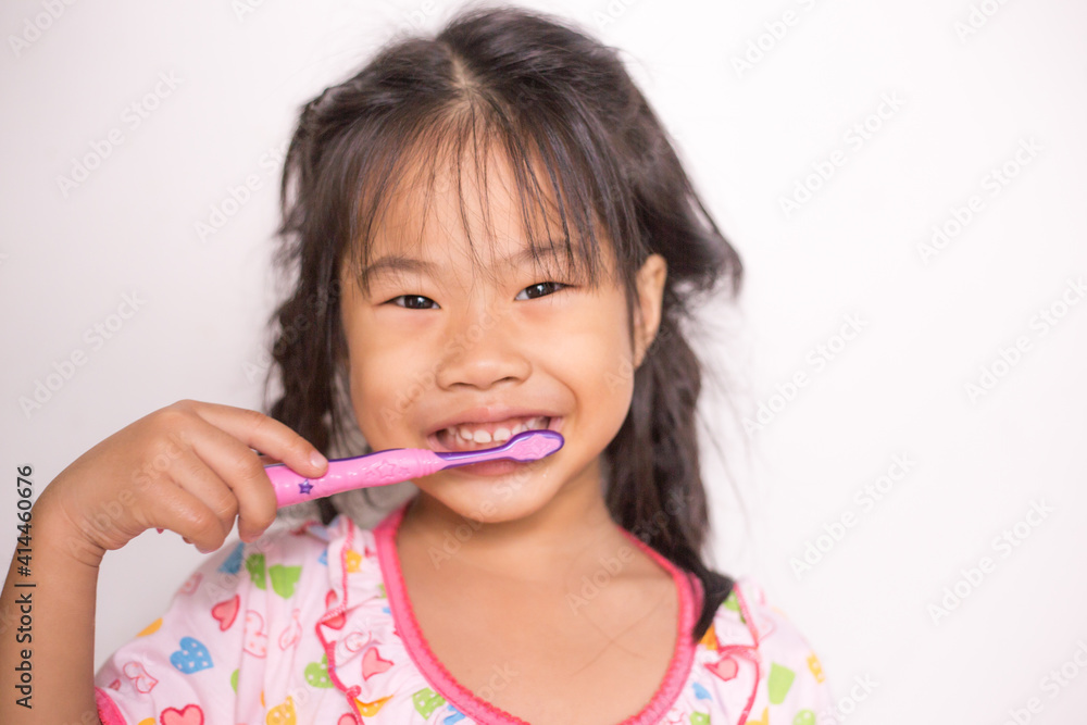 Little asian girl brushing her teeth in bathroom Little asian girl brushing her teeth in bathroom