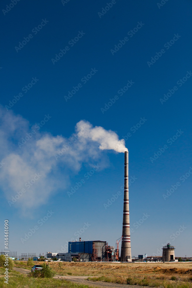 Ekibastuz, Kazakhstan. The highest electric power plant chimney in the world. White steam pollution. blue sky.