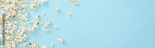 top view of salty popcorn scattered on blue, banner, cinema concept © LIGHTFIELD STUDIOS