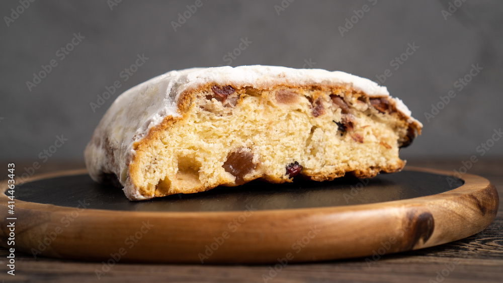 Golden authentic German Stollen on cutting board. Perfect Stollen pie on wooden table. Close up