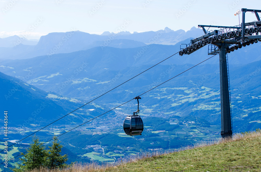 cable car takes tourists to the high mountains under the summer sun