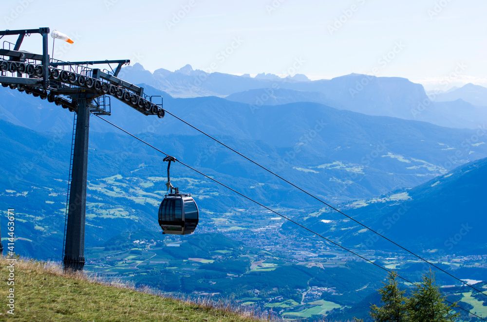 cable car takes tourists to the high mountains under the summer sun