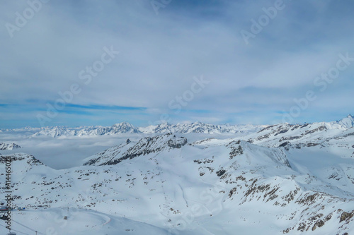 Beautiful and serene landscape of mountains covered with snow in Moelltaler Gletscher, Austria. Thick snow covers the slopes. Clear weather. There is a fog in the valley.