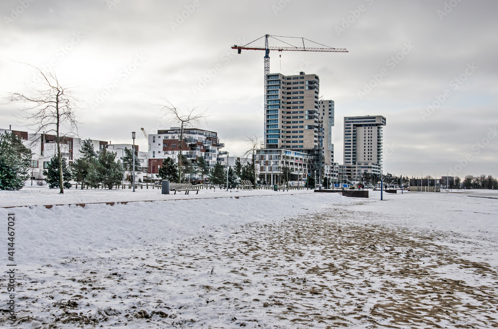 Rotterdam, The Netherlands, February 9, 2021: the snow-covered beach and boulevard of suburb Nesselande on a cold winter day