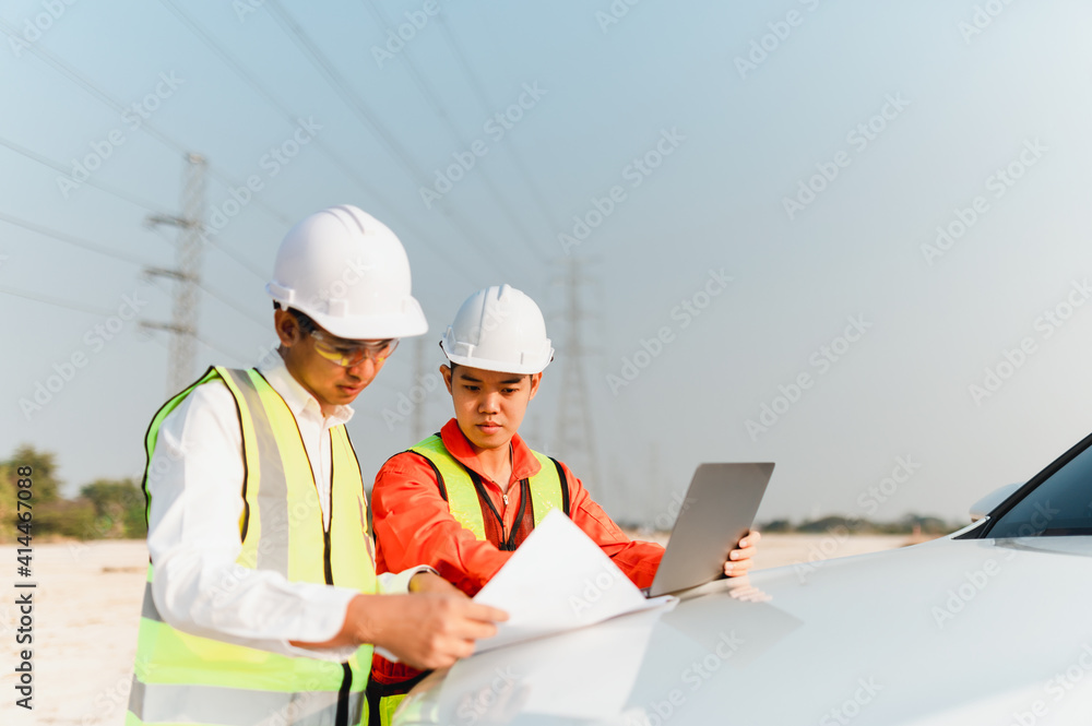 Engineers consult with the foreman to plan the installation of solar farms. Engineers discussion with foreman at construction site on the car bonnet. Engineers consult with the foreman to plan the installation of solar farms. Engineers discussion with foreman at construction site on the car bonnet.