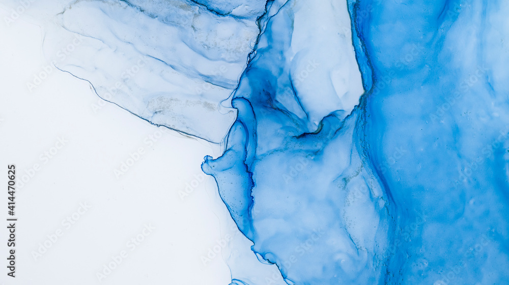 Naklejka premium Blue alcohol stains of paint with the addition of gold powder. Subtle waves of paint, abstract blue waves of the ocean, lines of marble. Liquid paints, gradient stains, painting.