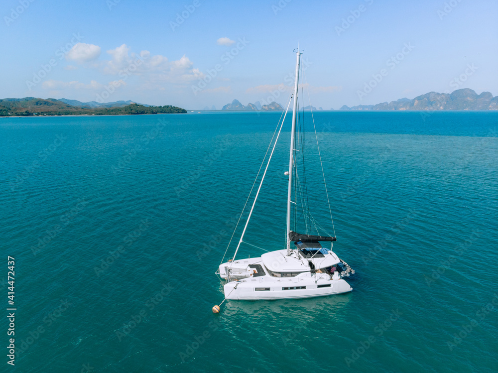 Top view of a lonely sailing yacht in the middle of the sea with a huge amount of blue space around against the backdrop of the sky and nature
