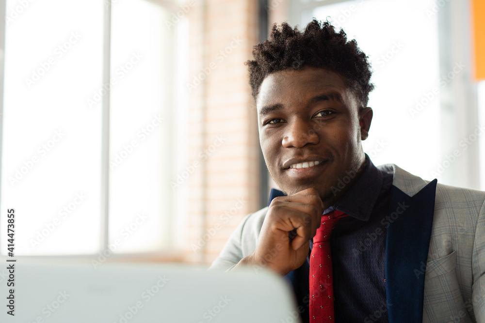 handsome young african man in office with laptop handsome young african man in office with laptop