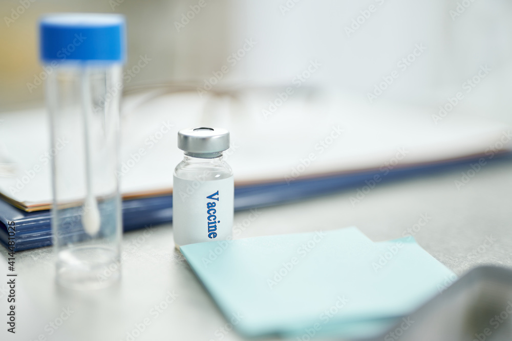 Test tube and bottle of vaccine on table in clinic