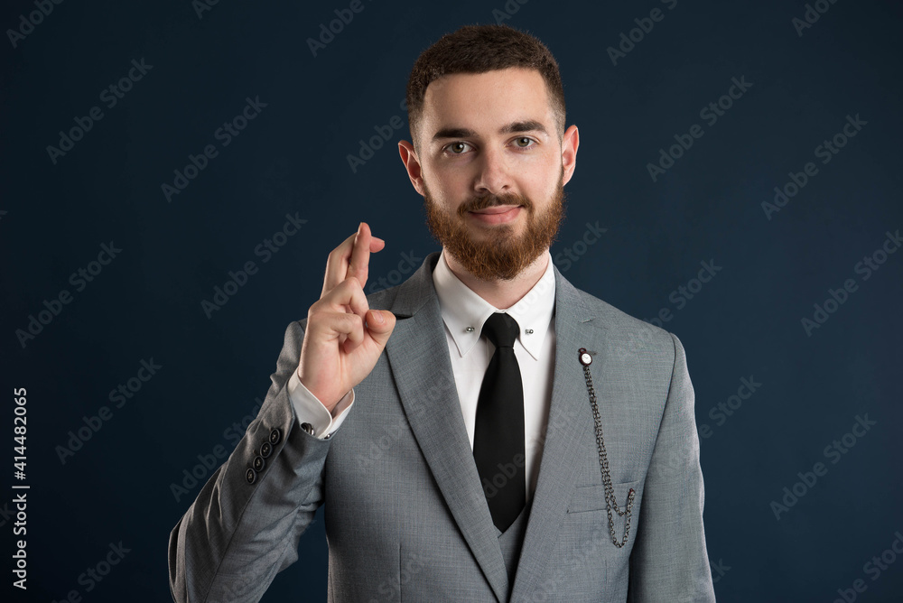 Young businessman showing good luck sign Young businessman showing good luck sign