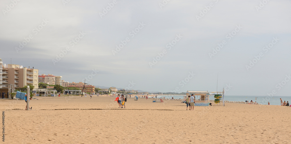  Tourists walking and sunbathing on the beach