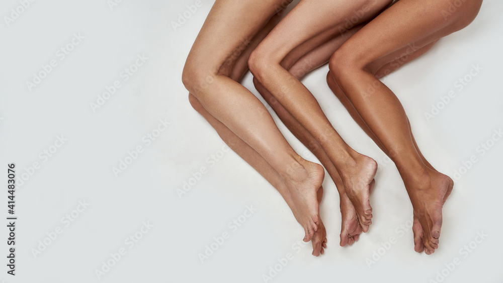 Folded legs of three ladies lying on the ground Folded legs of three ladies lying on the ground