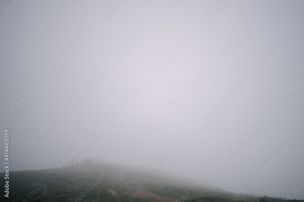 view from the top of mountain hoverla down, blue sky, clouds, thick fog, moss, conifers