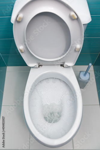 water flowing into a white toilet