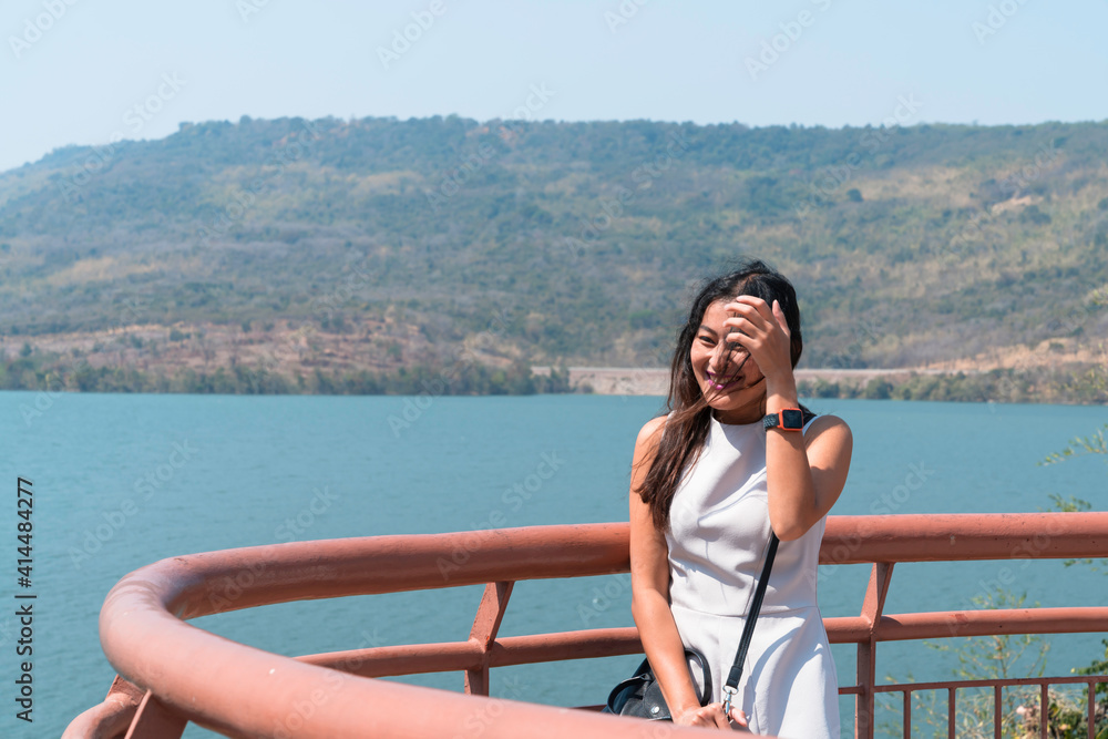 happy asian woman tourist relax at Lamtakong dam view point terrace, travel destination in Nakhon Ratchasima, Thailand