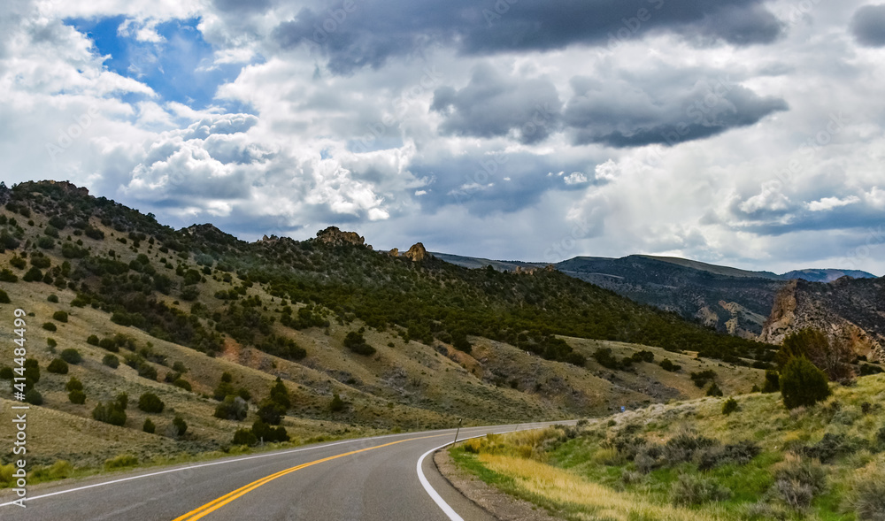 Straight flat asphalt road stretching into the distance beyond the horizon in Utah, US