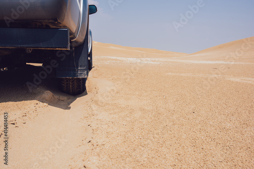 Wheel of car on sand in desert