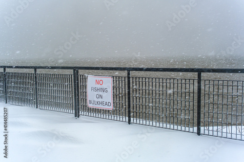 "NO FISHING ON BOARDWALK" sign on the Scenic Hudson Park boardwalk in Irvington, NY in a snowstorm