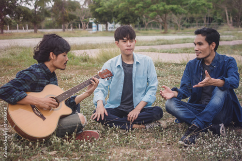 Group people Asian man friends playing guitar outdoor © Suriyo