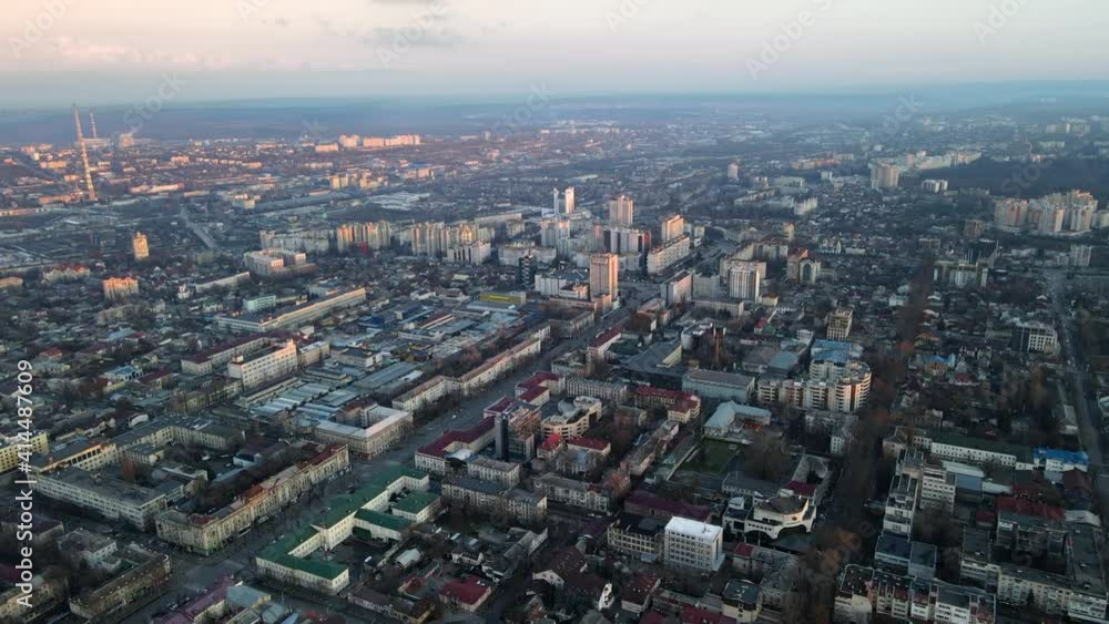 Aerial drone view of Chisinau at sunset. Panorama view of multiple buildings, roads with moving cars, bare trees, park, lake and hills. Moldova Aerial drone view of Chisinau at sunset. Panorama view of multiple buildings, roads with moving cars, bare trees, park, lake and hills. Moldova